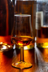 Dram of single malt scotch whisky and bottles on background