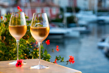 Tasting of local rose wine in summer with sail boats haven of Port Grimaud on background, Provence, France