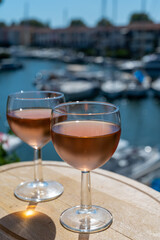 Tasting of local rose wine in summer with sail boats haven of Port Grimaud on background, Provence, France