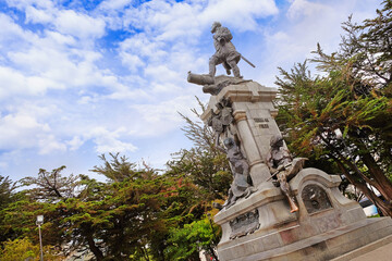 Monument of Ferdinand Magellan in the Plaza de Armas, Punta Arenas, Chile, surrounded by green...