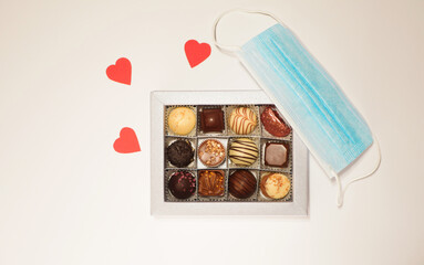Valentine's day while pandemic. Coronavirus new normal. Chocolate candies box gift. Face mask and hearts 