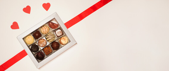 Candies in the box banner. Valentine's day background. Copy space. Hearts made of paper 