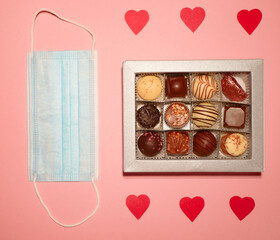 Valentine's day while pandemic. Coronavirus new normal. Chocolate candies box gift. Face mask and hearts 