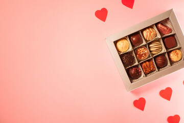 Chocolate candies box. Valentine's day gift. Red hearts paper pattern. Pink background. Copy space