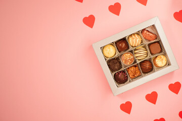 Chocolate candies box. Valentine's day gift. Red hearts paper pattern. Pink background. Copy space