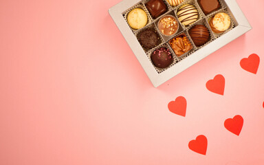 Chocolate candies box. Valentine's day gift. Red hearts paper pattern. Pink background. Copy space