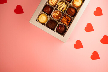 Chocolate candies box. Valentine's day gift. Red hearts paper pattern. Pink background. Copy space