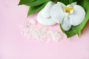 Flat lay composition with white spa sea salt and white orchid with space for text on pink background. Meditation and minimalism. copyspase flatlay. Spa cosmetic and Beauty concept, top view.