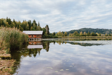 Floating house on a beautiful lake during autumn. Perfect water reflection on the lake