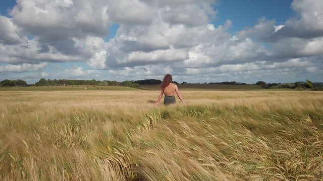 Girl walking through a wheat field