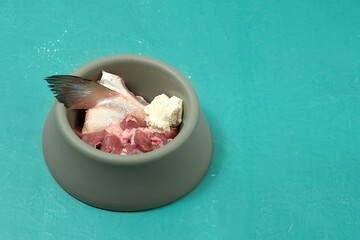 Natural dog food in bowl. Raw fish, meat, cottage cheese. BARF diet. Homemade dog food.
