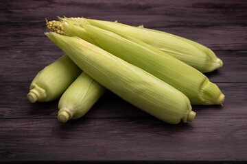 corn cobs on a dark wooden table