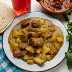 Mexican longaniza with green sauce and potato on white background
