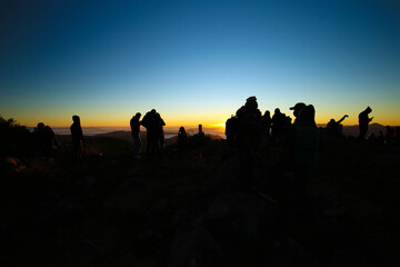 Enjoying the sunset with friends in the mountains, mexican people