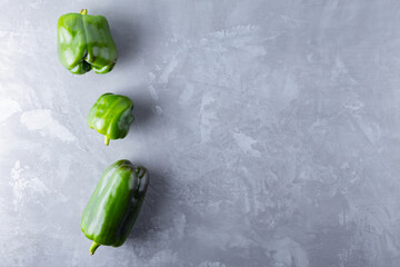 Ugly bell pepper on ultimate gray background. Deformed homegrown green bell pepper on the table....