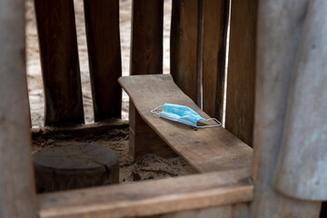 Child forgets Covid-19 mask on playground in wooden hut. Corona in children and social distancing