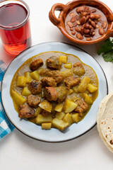 Mexican longaniza with green sauce and potato on white background