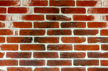 The wall is of old red brick with white seams. Texture. Background.