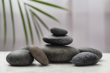 Fototapeta na wymiar Spa stones on white table indoors. Zen and harmony