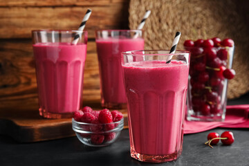 Tasty fresh milk shake with berries on black table. Space for text