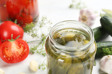 Glass jar of pickled cucumbers on table, closeup. Space for text