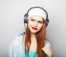 lifestyle and people concept: young woman with headphones listening music. Hipster style.