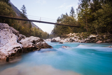Hiking bridge with view at Soca River with crystal clear turquoise blue water. Kranjska Gora,...
