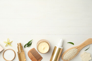Flat lay composition with hair care cosmetic products on white wooden table. Space for text