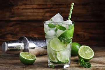 Delicious mojito and ingredients on wooden table