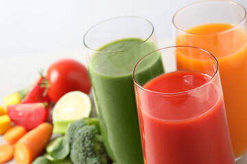 Different tasty juices in glasses on white background, closeup. Space for text
