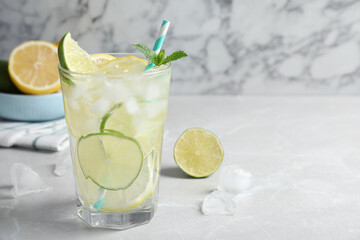 Delicious lemonade with soda water and mint on light grey table, space for text. Fresh summer cocktail