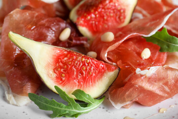 Delicious figs and proscuitto on plate, closeup