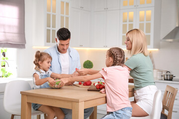 Happy family cooking together at table in modern kitchen