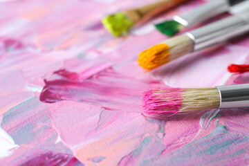 Obraz premium Set of different brushes on abstract colorful paint, closeup
