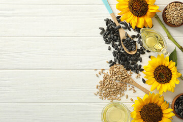 Flat lay composition with sunflower oil on white wooden table, space for text