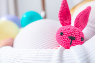 Beautiful pregnant woman with toy on white background