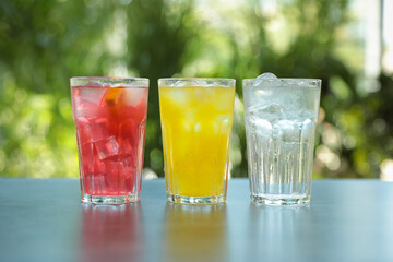 Delicious refreshing drinks in glasses on grey table outdoors