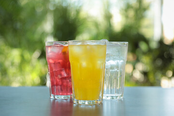 Delicious refreshing drinks in glasses on grey table outdoors