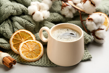 Composition with hot drink and warm plaid on light table