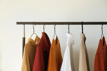 Rack with stylish clothes indoors, closeup. Interior design