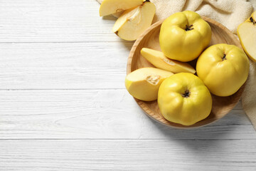 Fresh ripe organic quinces on white wooden table, flat lay. Space for text