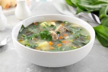 Delicious sorrel soup with meat served on marble table, closeup