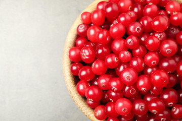 Tasty ripe cranberries on grey table, top view