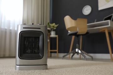 Modern electric infrared heater on floor in room interior, closeup. space for text