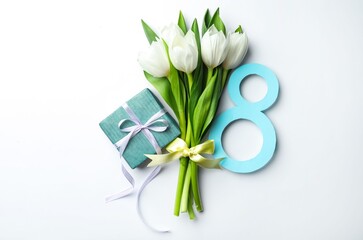 8 March greeting card design with tulips and gift on white background, top view