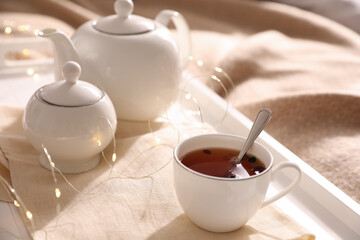White tray with ceramic tea set on fabric