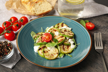 Delicious grilled zucchini slices served with cottage cheese and tomatoes on grey table, closeup