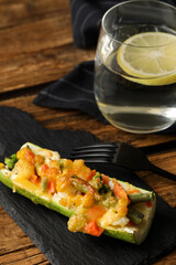 Baked stuffed zucchini served on wooden table, closeup