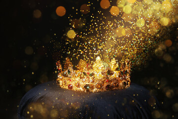 Fantasy world. Beautiful golden crown lit by magic light on pillow