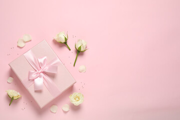 Fototapeta na wymiar Elegant gift box and beautiful flowers on pink background, flat lay. Space for text
